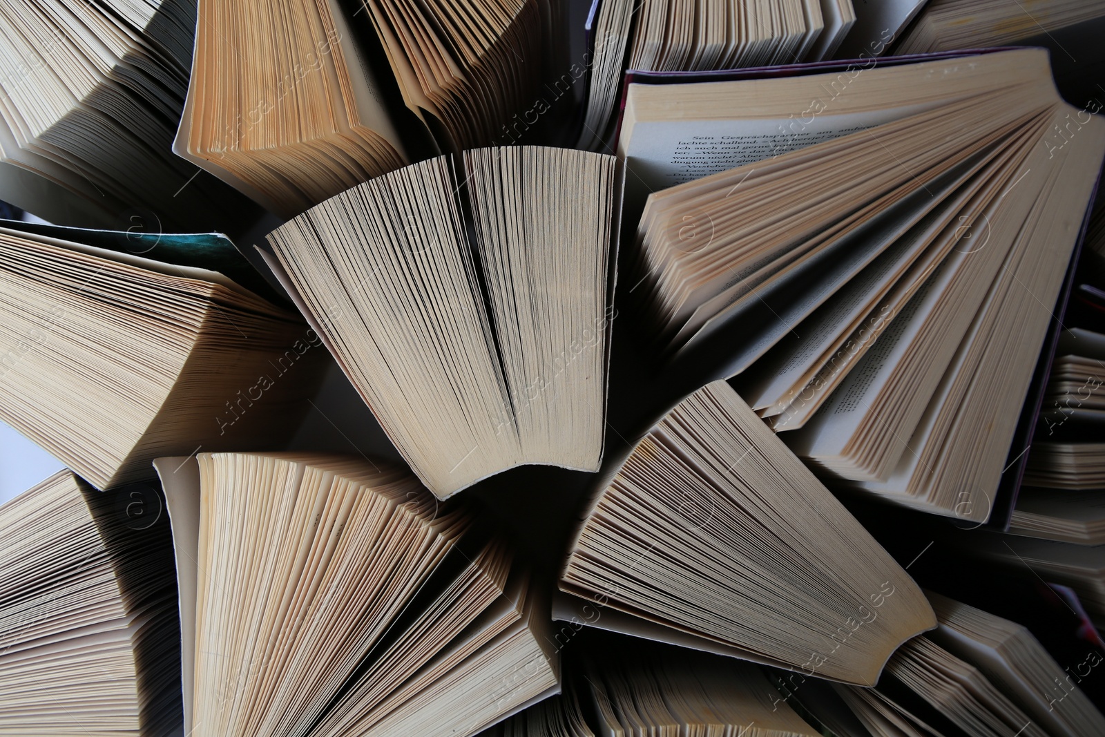 Photo of Collection of different books on white shelf, above view