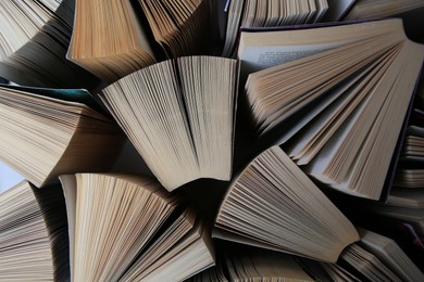 Collection of different books on white shelf, above view