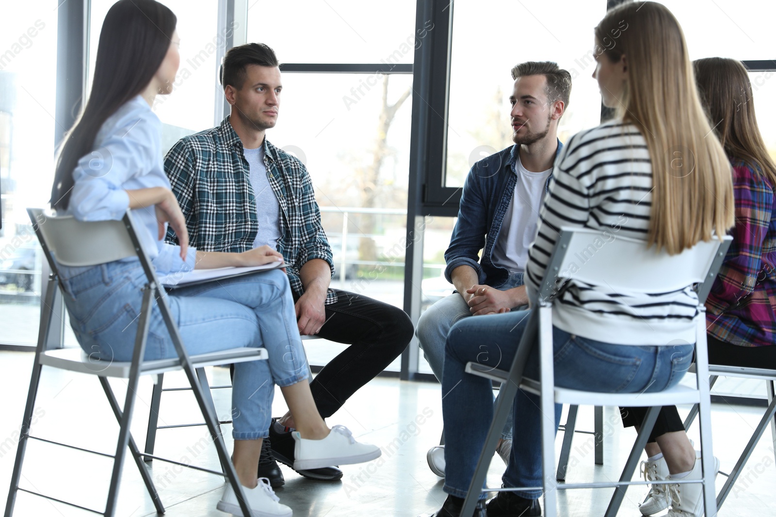 Photo of Psychotherapist working with patients in group therapy session indoors