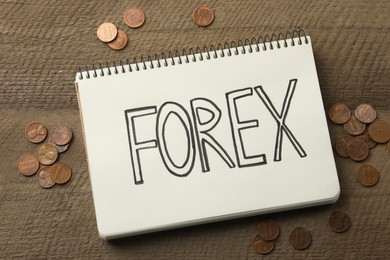 Photo of Notebook with word Forex and coins on wooden table, flat lay