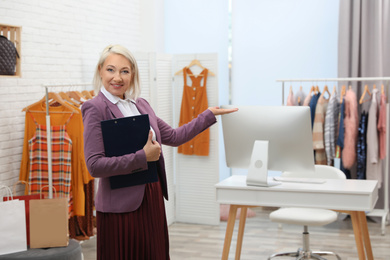 Photo of Female business owner with clipboard in boutique