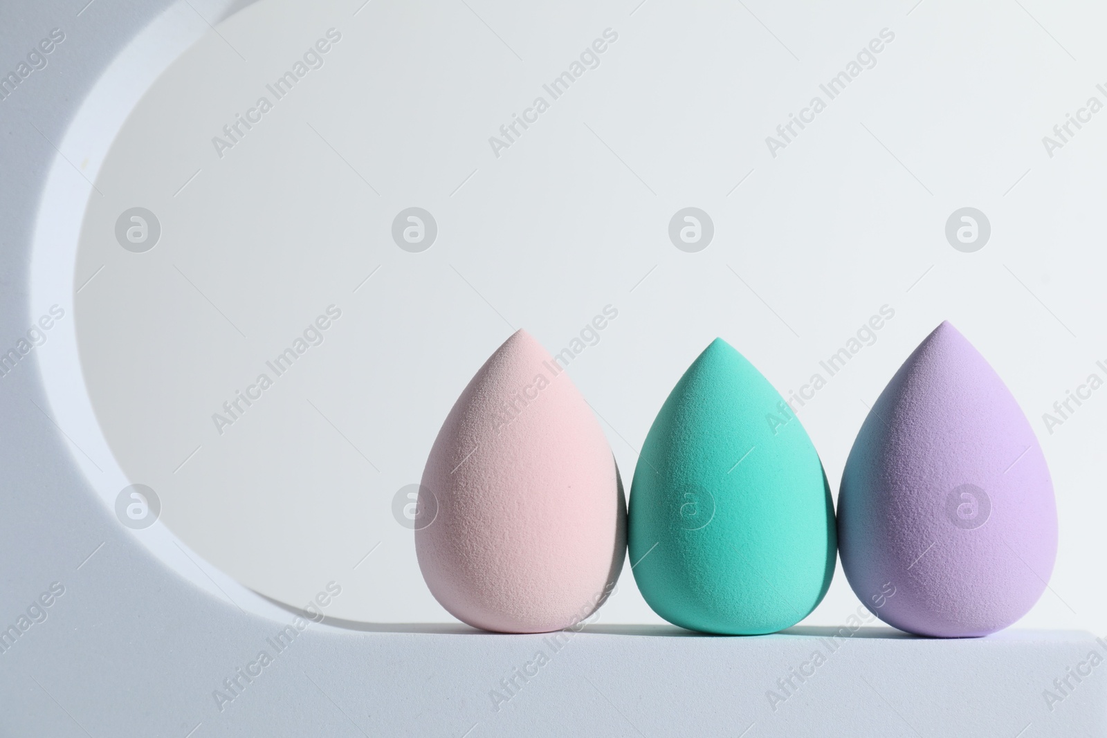 Photo of Stylish presentation of makeup sponges on white background