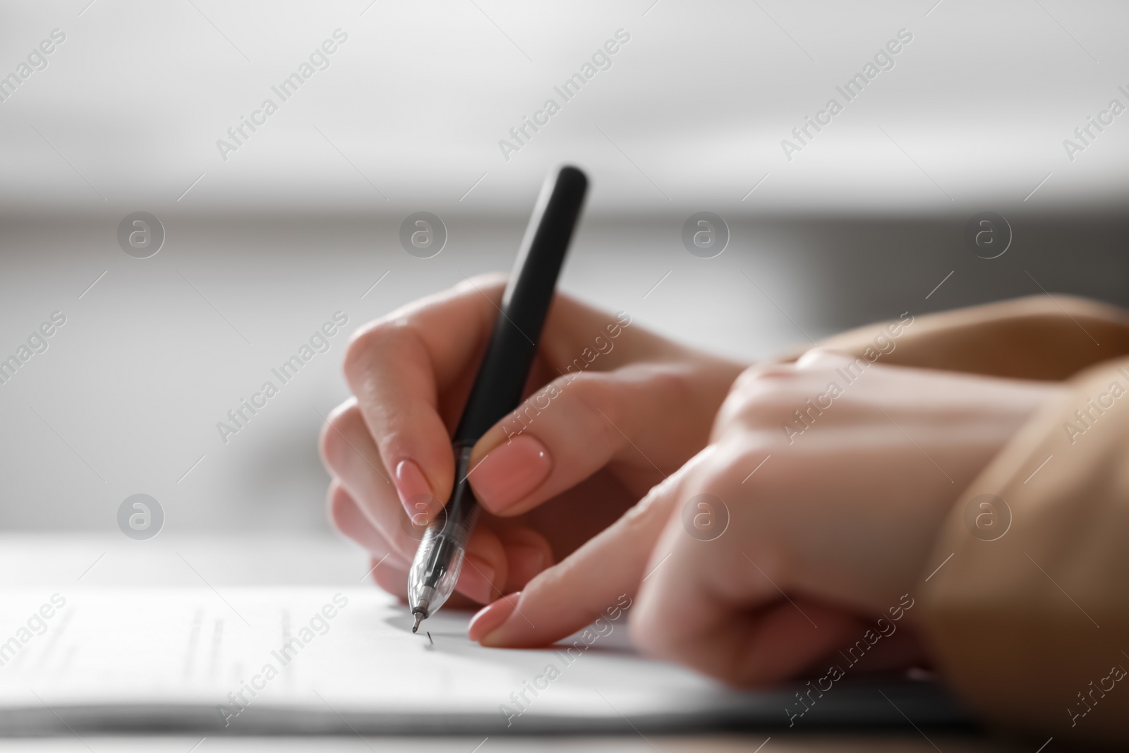 Photo of Woman signing documents at table in office, closeup. Space for text