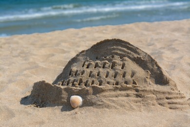 Photo of Beach with sand castle near sea on sunny day