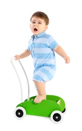 Cute baby playing with toy walker on white background