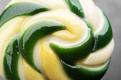 Photo of Colorful lollipop swirl on grey background, closeup