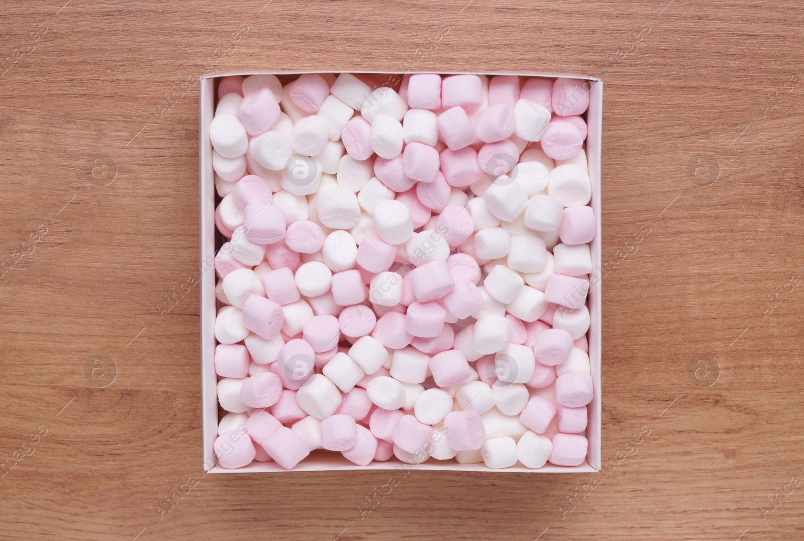 Photo of Box with delicious marshmallows on wooden table, top view