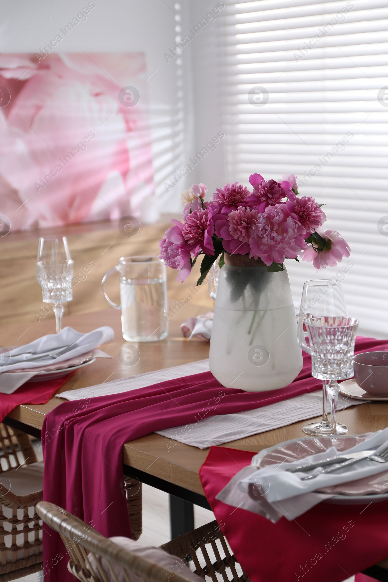 Photo of Pink peonies on table with beautiful setting in dining room