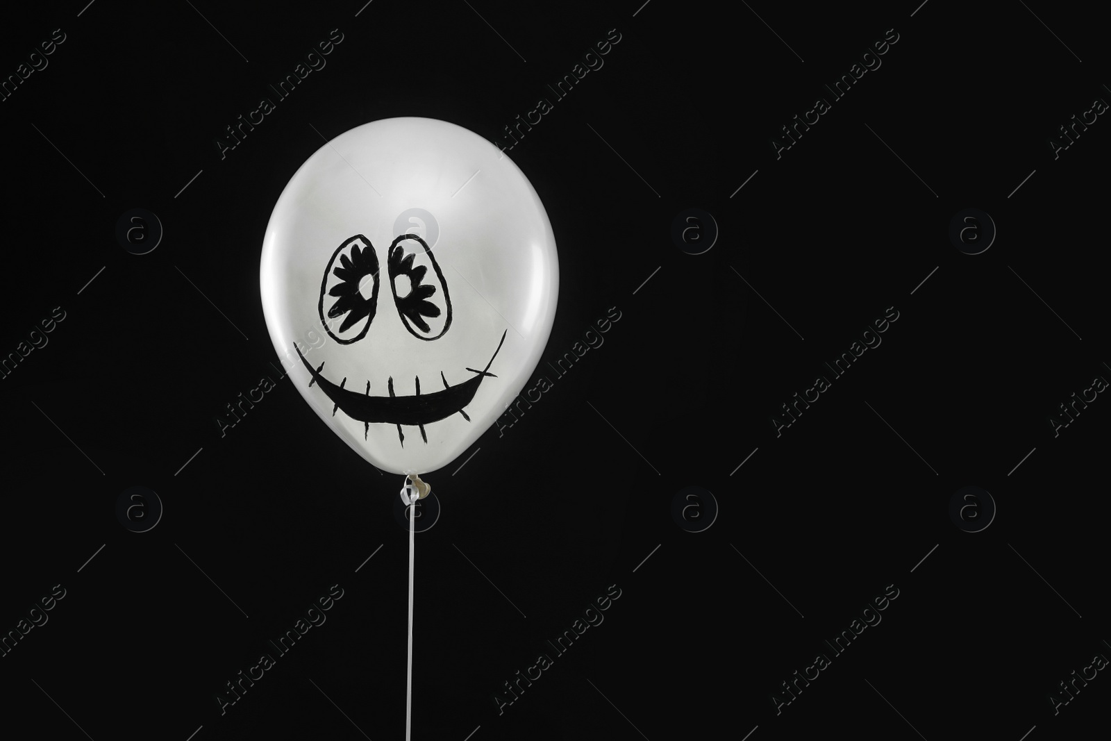 Photo of Spooky balloon for Halloween party on black background, space for text