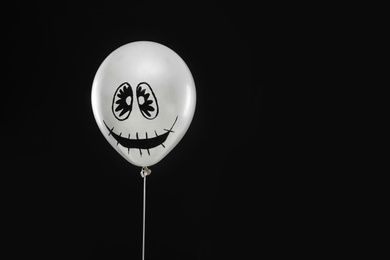 Photo of Spooky balloon for Halloween party on black background, space for text