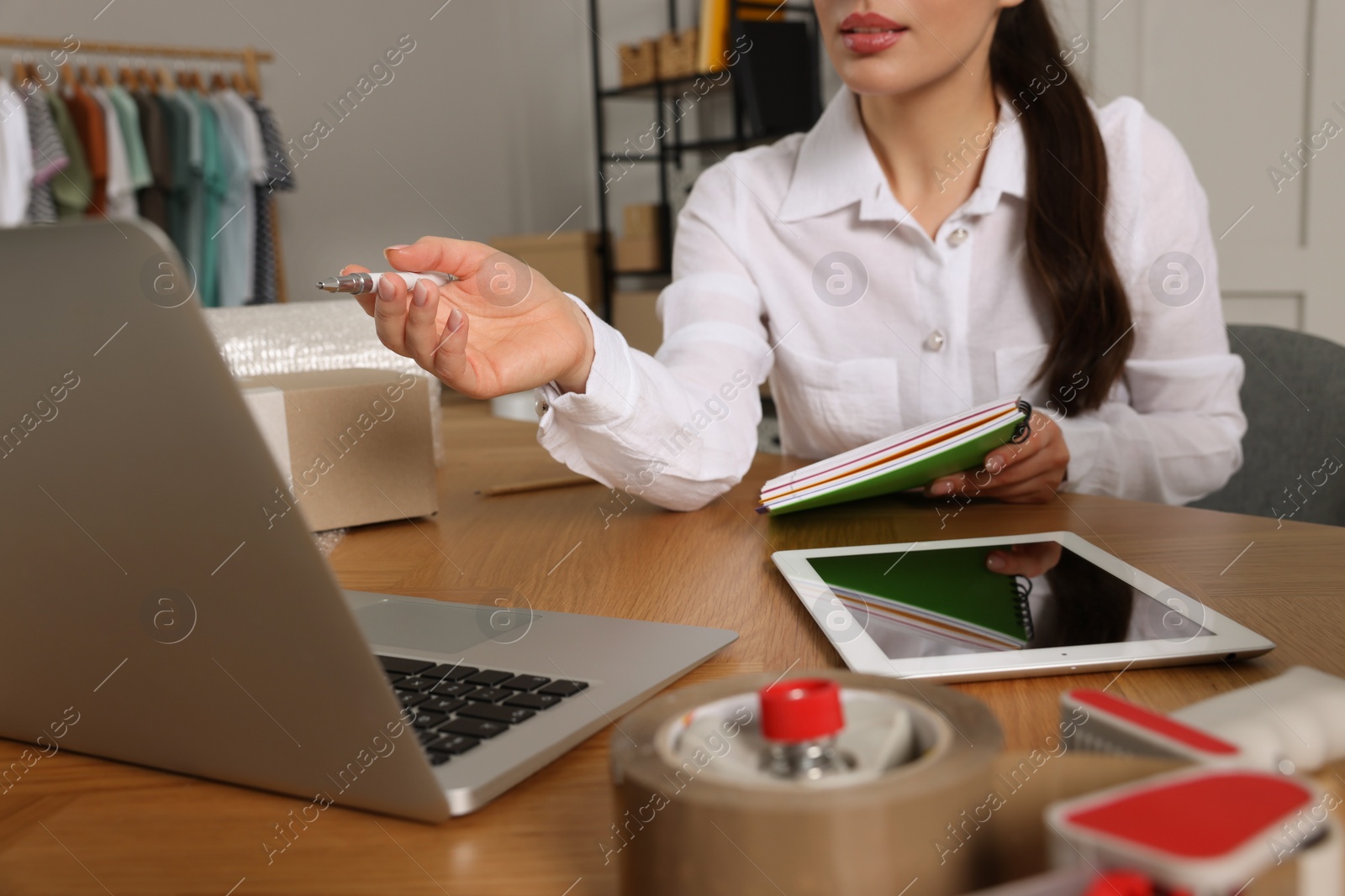 Photo of Seller working with laptop in office, closeup. Online store