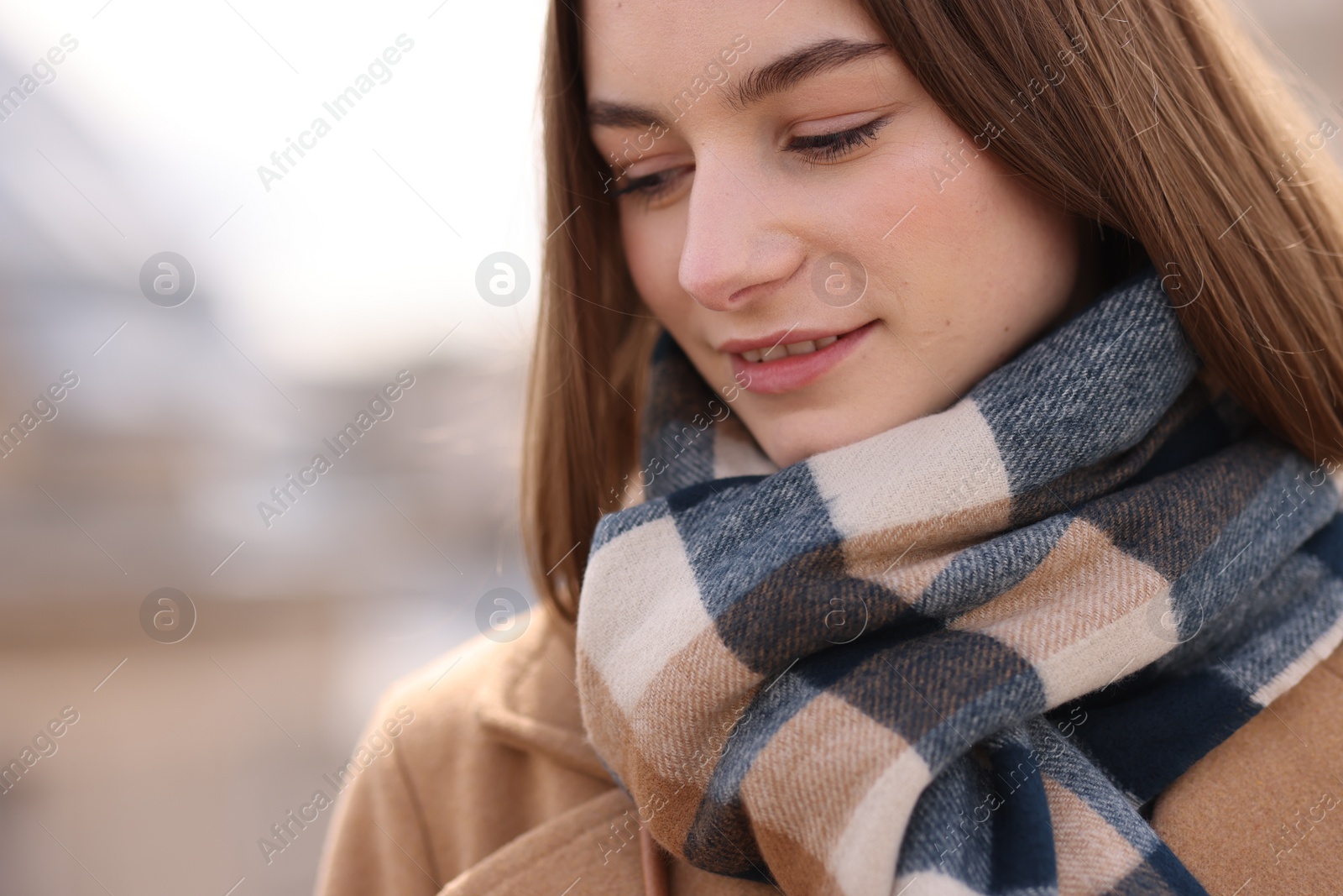 Photo of Beautiful woman in warm scarf outdoors, space for text