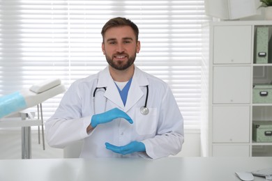 Young doctor holding something at table in clinic