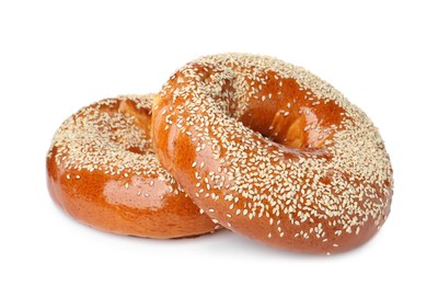 Photo of Delicious fresh bagels with sesame seeds on white background