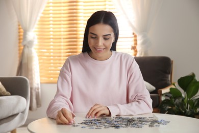 Photo of Young woman playing with puzzles at home