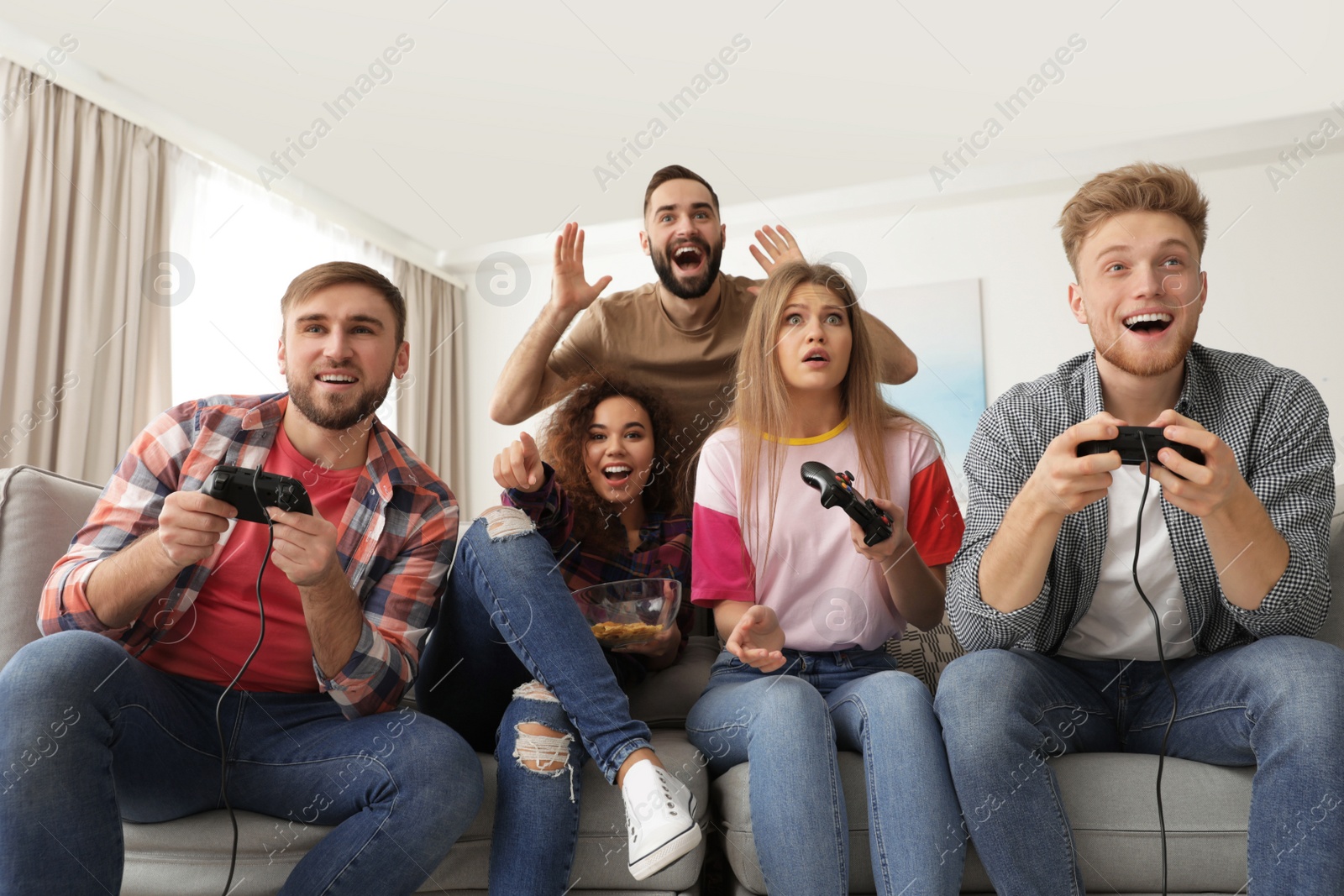 Photo of Emotional friends playing video games at home