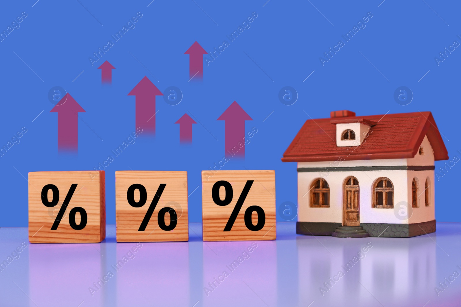 Image of Mortgage rate rising illustrated by upward arrows and percent signs. House model and wooden cubes on table