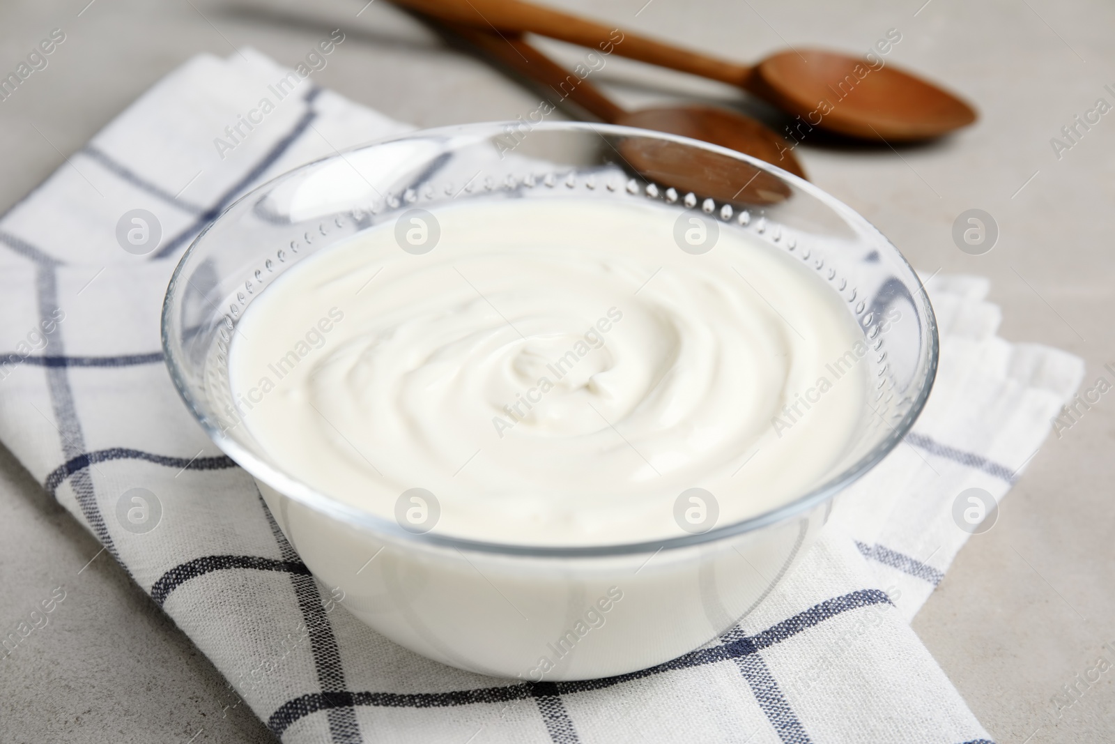 Photo of Glass bowl with creamy yogurt served on table