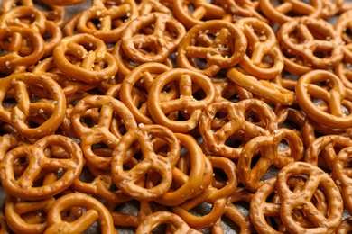 Many delicious pretzel crackers as background, closeup view