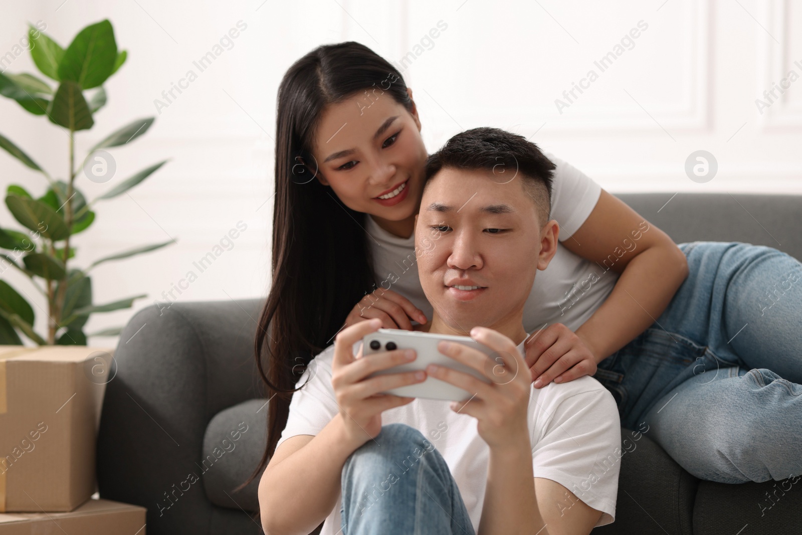 Photo of Happy couple with smartphone in their new apartment