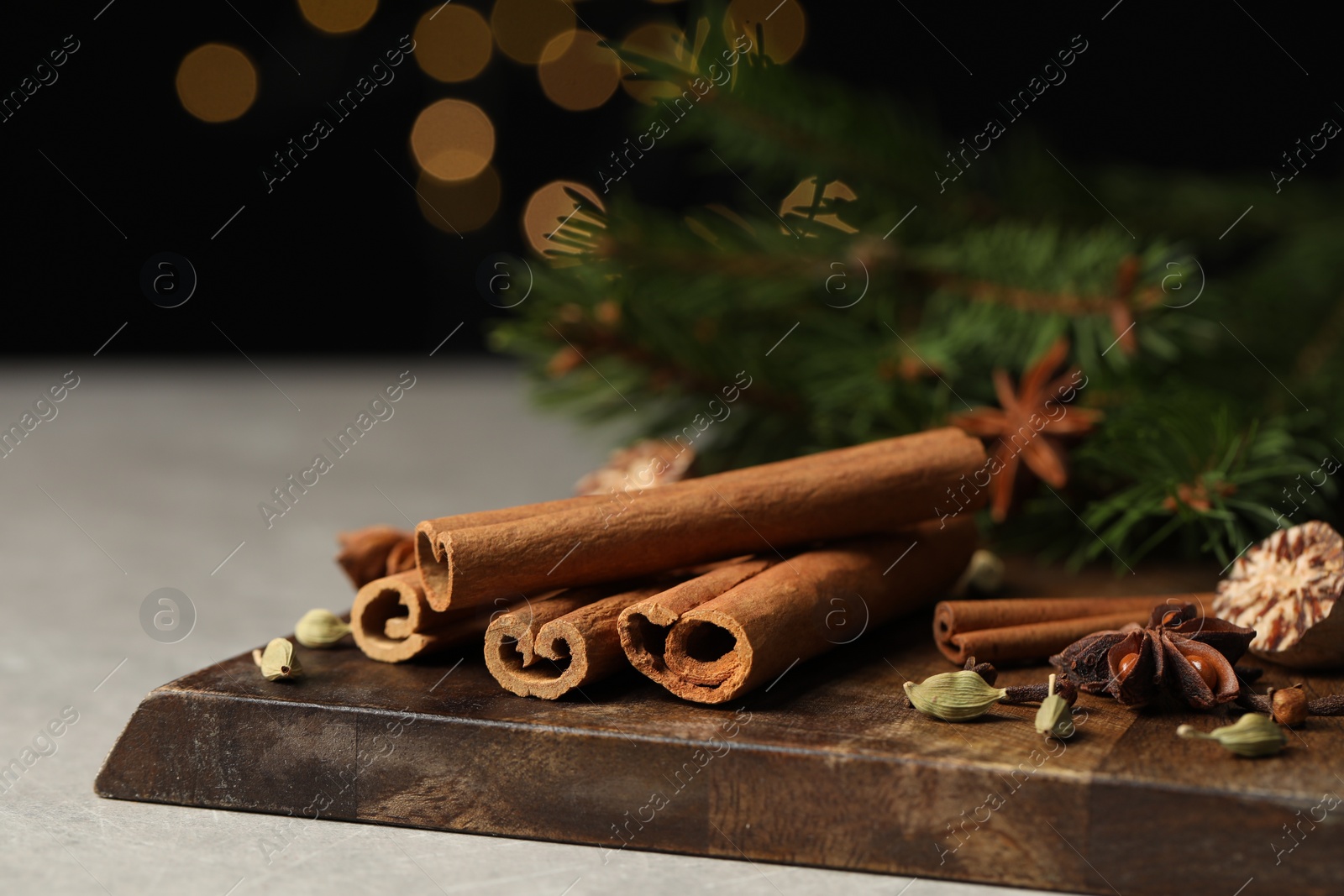 Photo of Different aromatic spices on light table against black background, closeup. Space for text