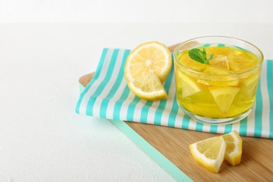 Glass of lemon jelly served on white table. Space for text