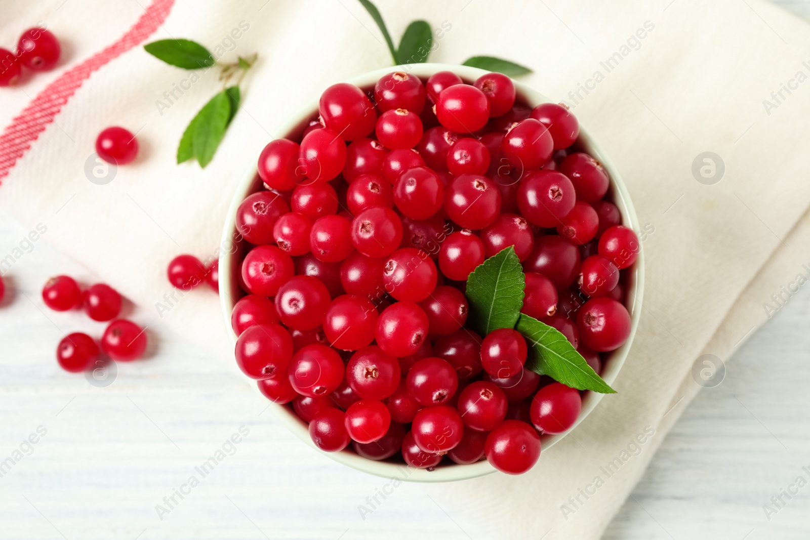 Photo of Tasty ripe cranberries on white wooden table, flat lay