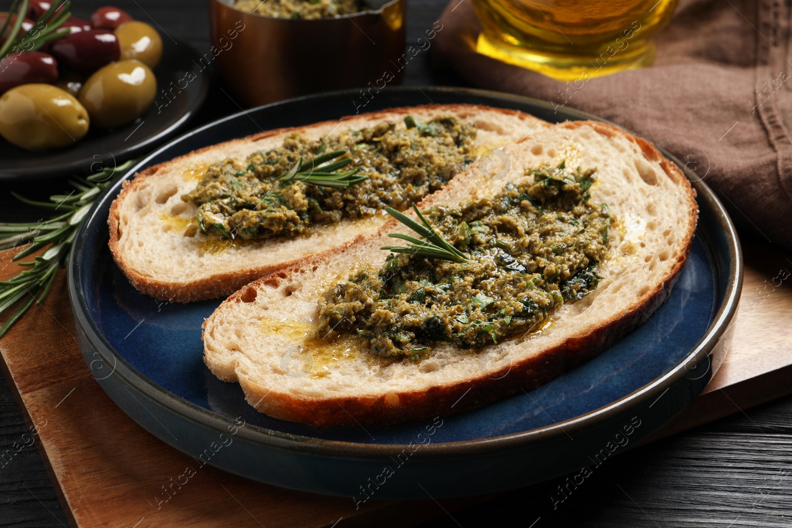 Photo of Tasty bruschettas with pesto and rosemary on plate, closeup