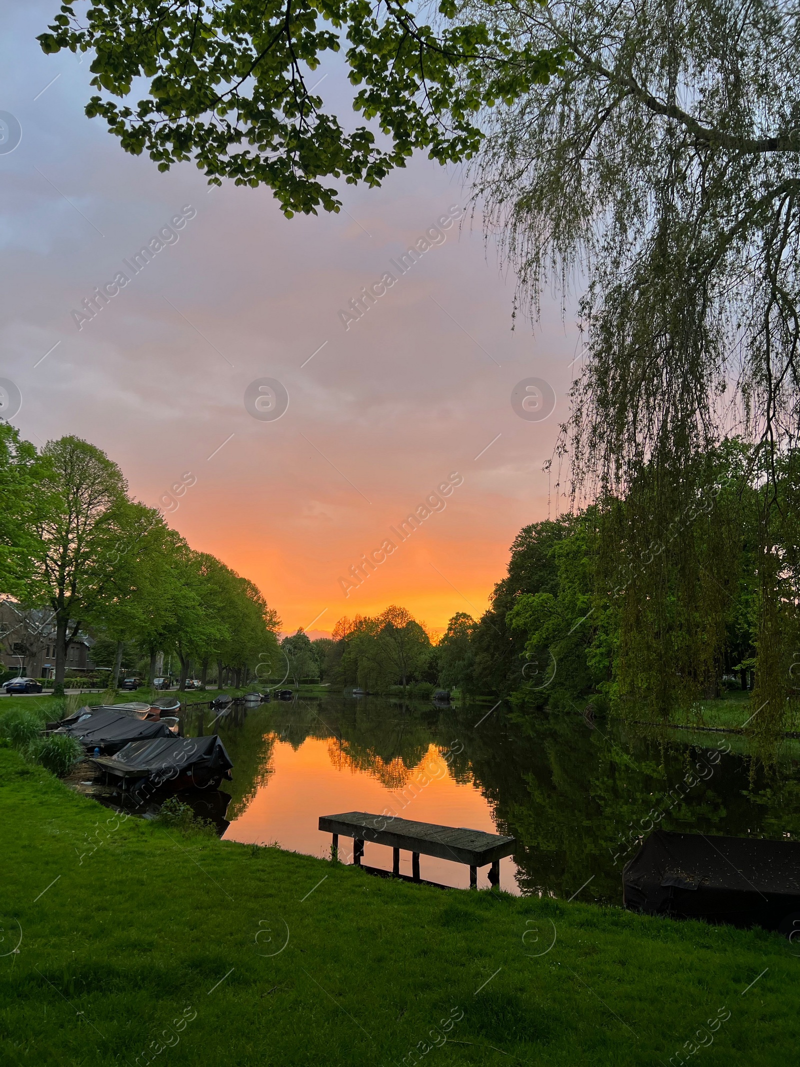 Photo of Scenic view of canal with moored boats at sunset