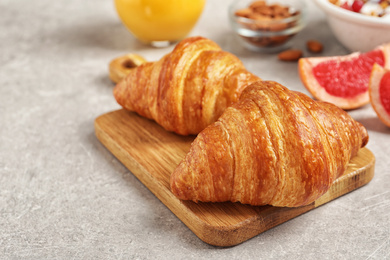 Tasty fresh croissants on light grey table. Healthy breakfast