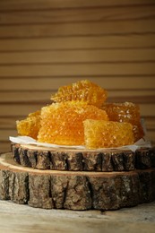 Photo of Natural honeycombs and wooden dipper on rustic table, space for text