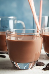 Glass of tasty chocolate milk on wooden table, closeup. Dairy drink