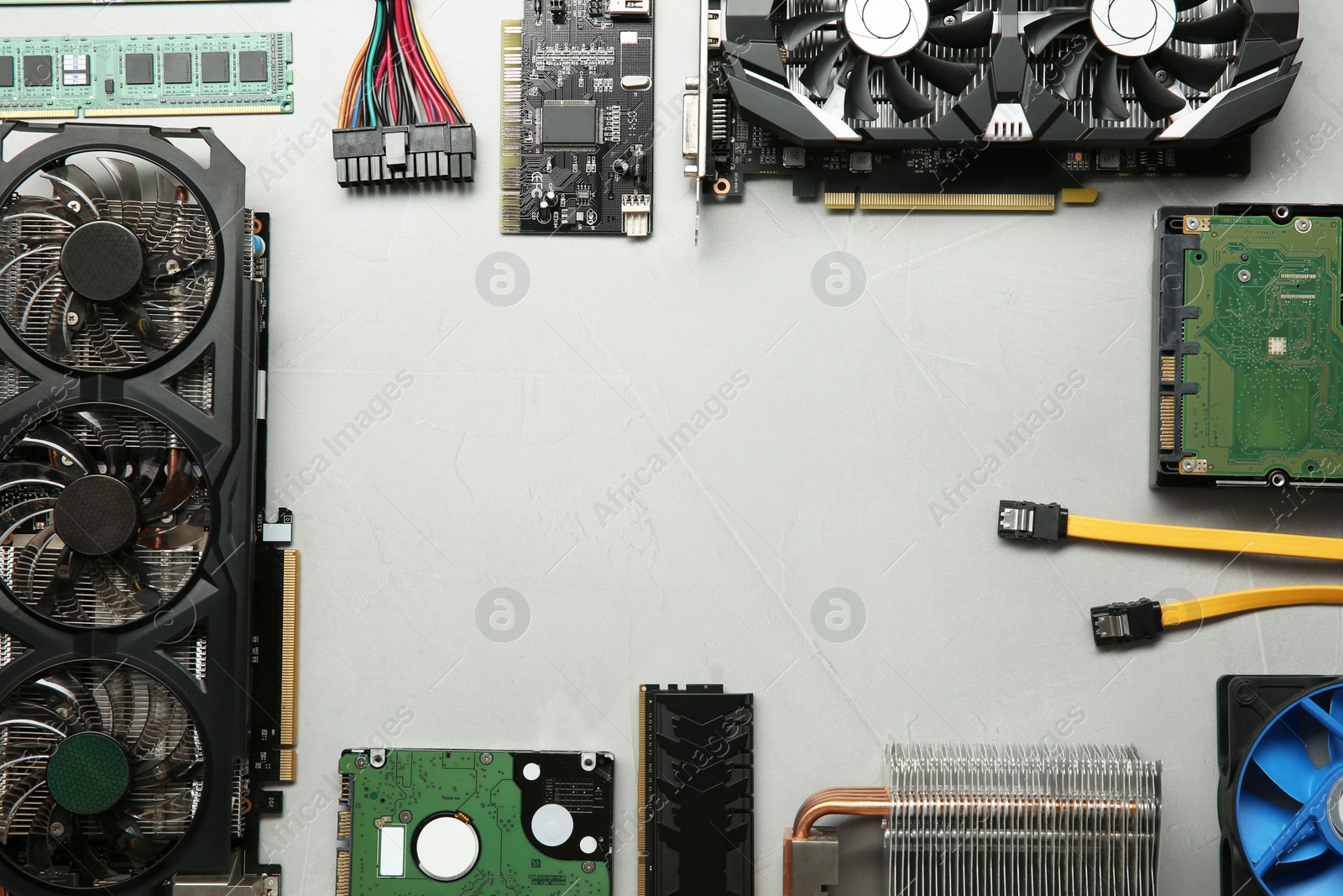 Photo of Frame of graphics card and other computer hardware on gray textured background, flat lay. Space for text