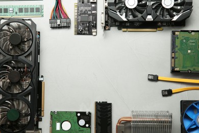 Frame of graphics card and other computer hardware on gray textured background, flat lay. Space for text