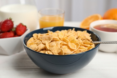 Photo of Bowl with healthy cornflakes for breakfast served on table, closeup