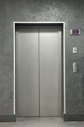 Closed silver stylish elevator door in hall