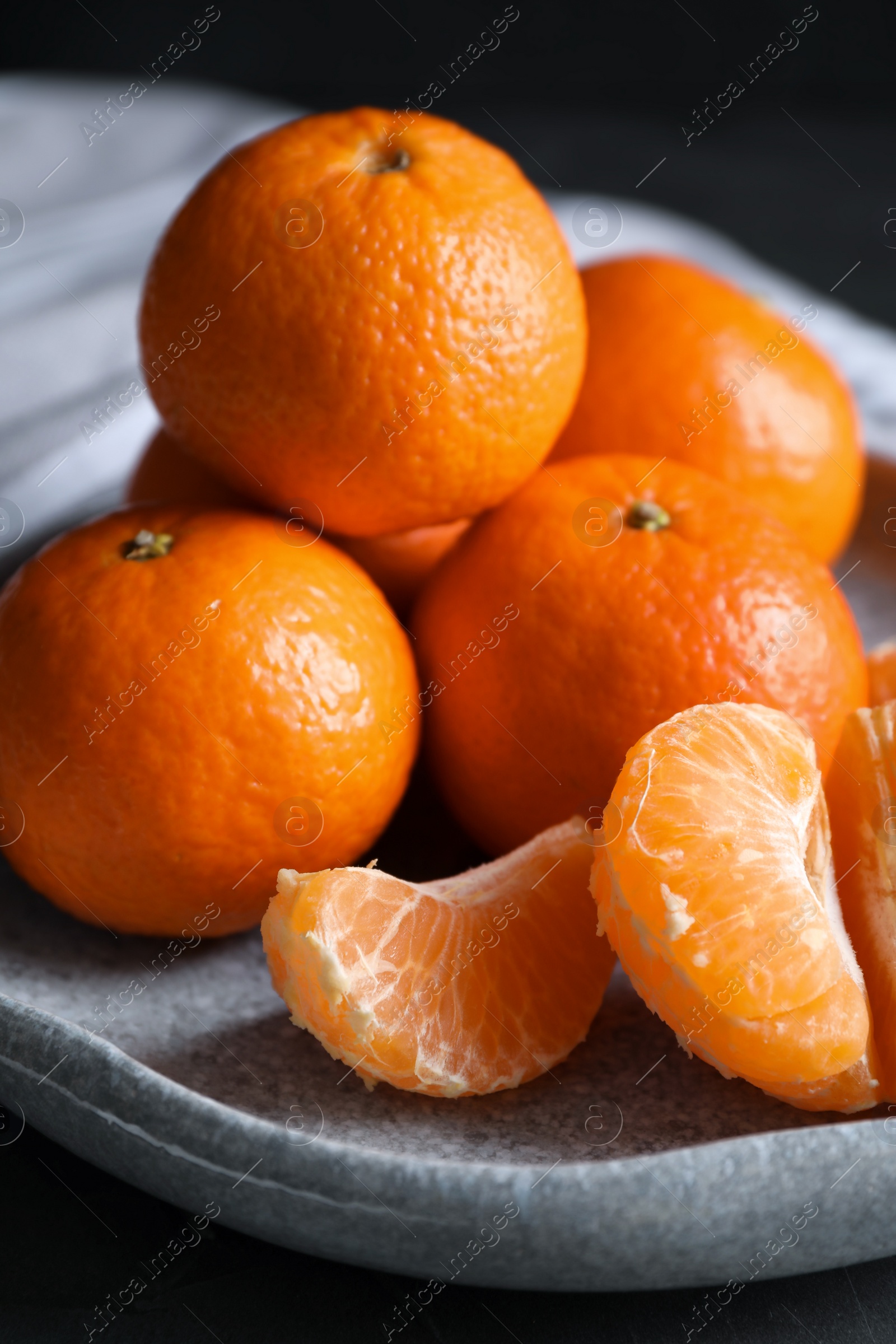 Photo of Delicious fresh ripe tangerines on plate, closeup