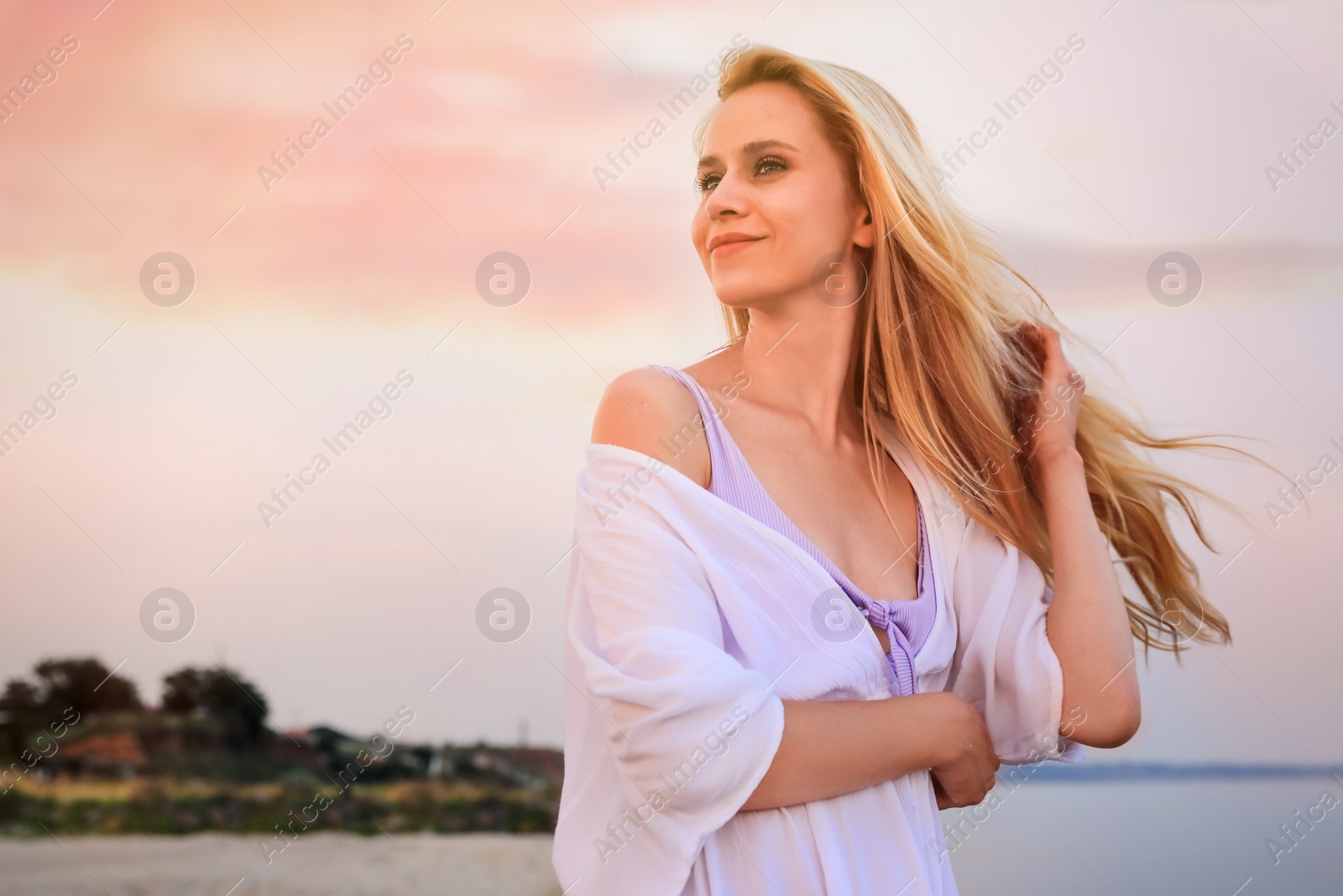 Photo of Beautiful young woman on beach in evening, space for text