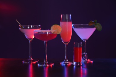 Many different alcoholic drinks on table against dark background