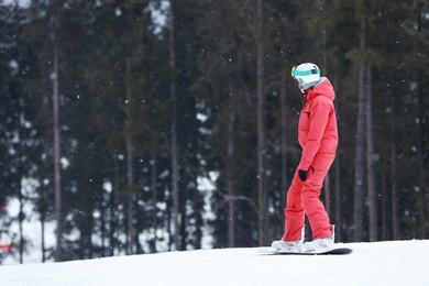 Snowboarder on slope at resort, space for text. Winter vacation