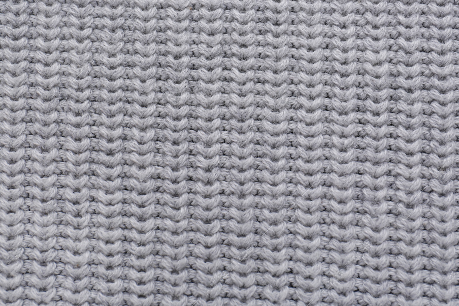 Photo of Grey knitted fabric as background, top view