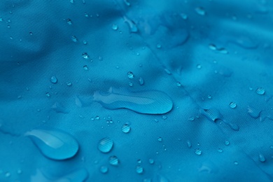 Photo of Light blue waterproof fabric with water drops as background, closeup