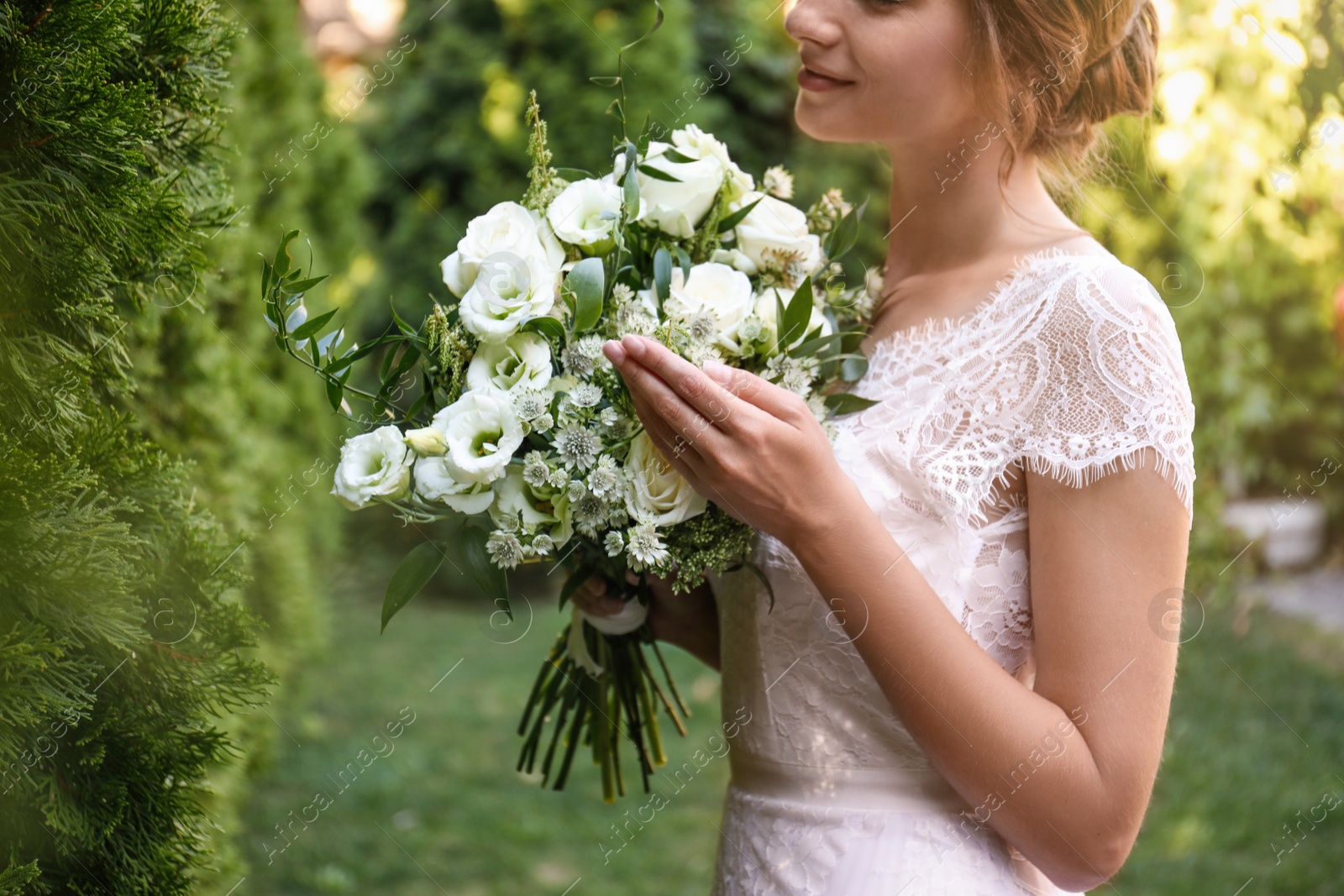 Photo of Bride in beautiful wedding dress with bouquet outdoors, closeup