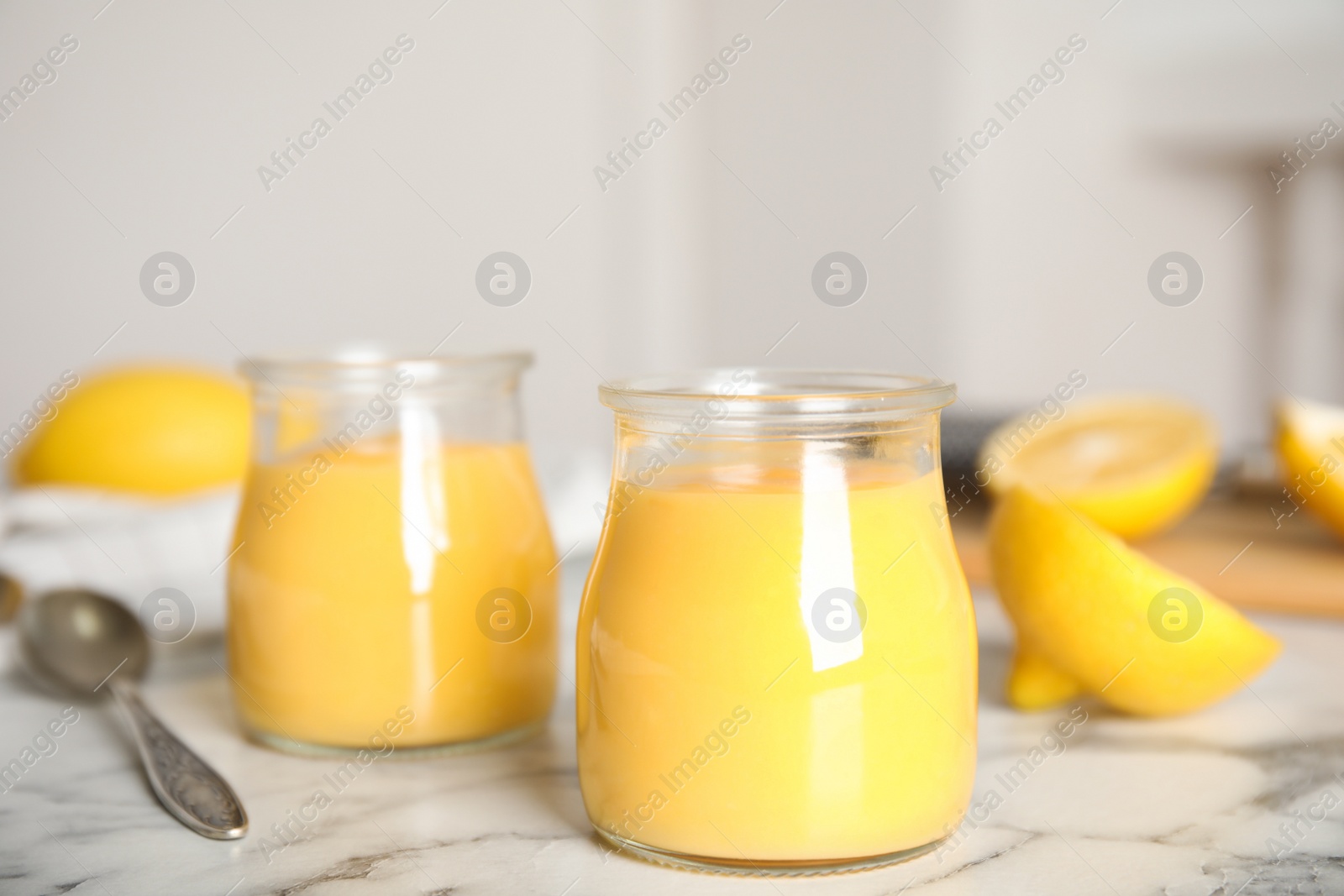 Photo of Delicious lemon curd on white marble table