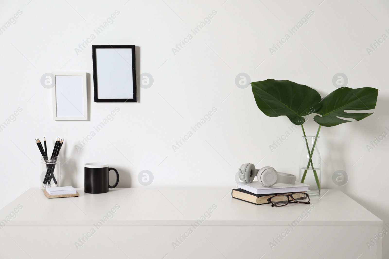 Photo of Comfortable workplace with white desk near wall at home