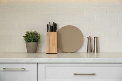 Photo of Different kitchen items and houseplant on countertop indoors