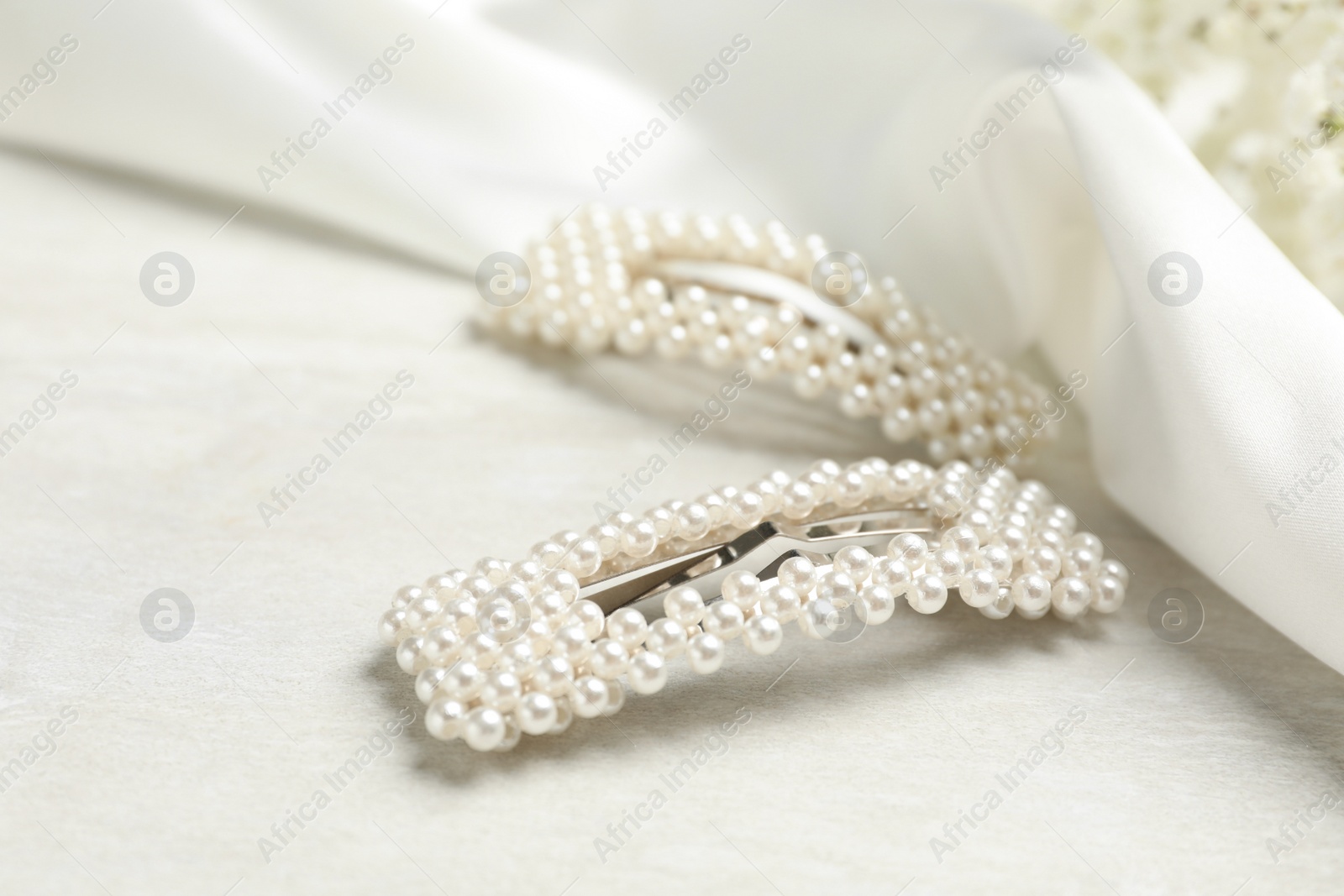 Photo of Beautiful hair clips with pearls on white table
