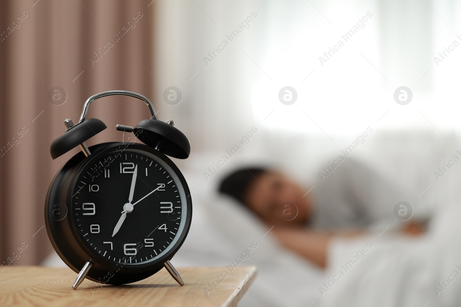 Photo of Woman sleeping in bedroom, focus on alarm clock. Space for text