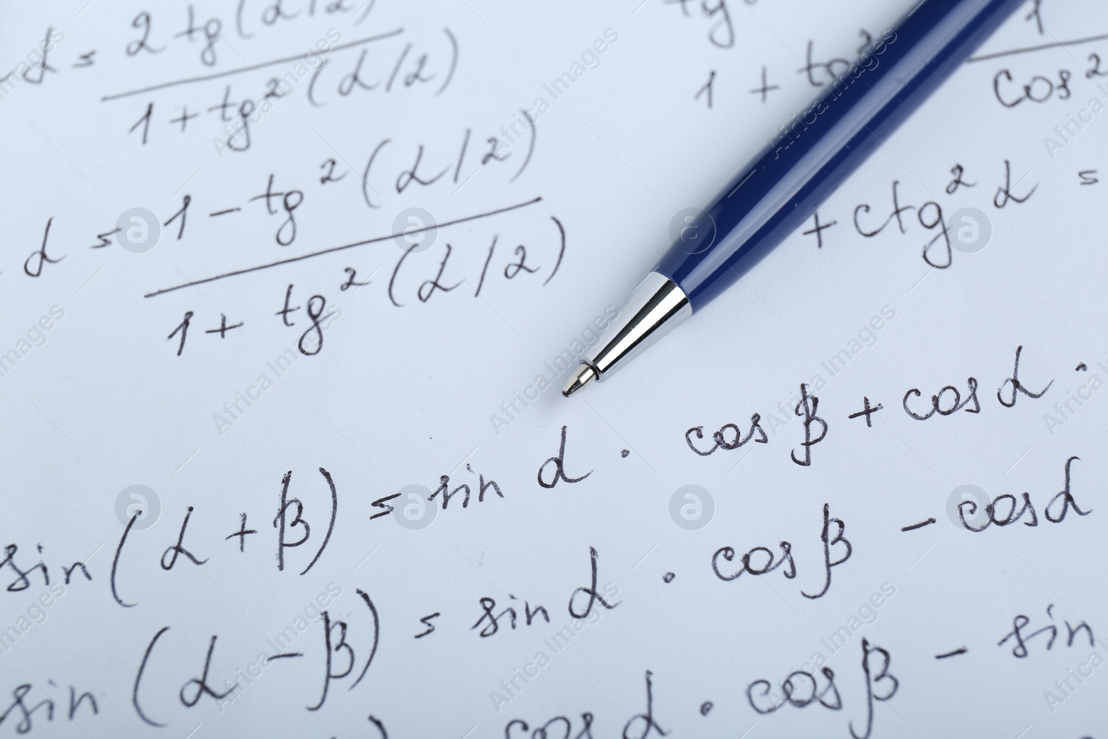 Photo of Sheet of paper with different mathematical formulas and pen, closeup