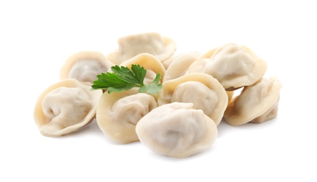 Photo of Pile of boiled dumplings with parsley leaves on white background